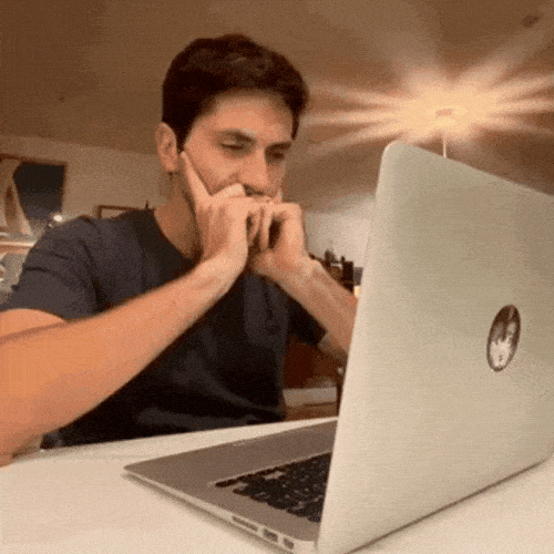 Man sitting at a laptop looking confused