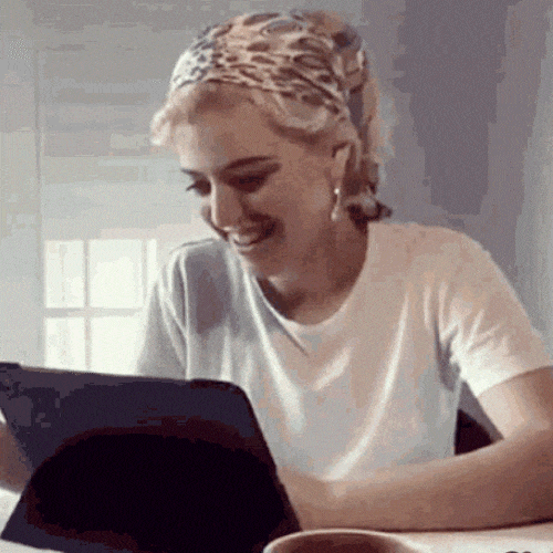 Person smiling while using a tablet at home