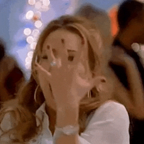 A woman shows off an engagement ring on her hand and squeals with excitement.
