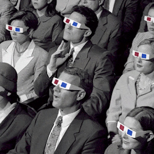 A black-and-white cinema audience in 3D glasses stares silently at the screen.