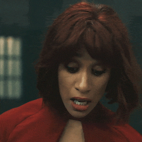 Woman in a red outfit speaking with conviction 