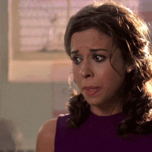A woman with curly hair looks worried and close to tears.