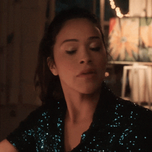 &bull;	Woman reacting with a brief &ldquo;oh no&rdquo; expression in a dim indoor setting