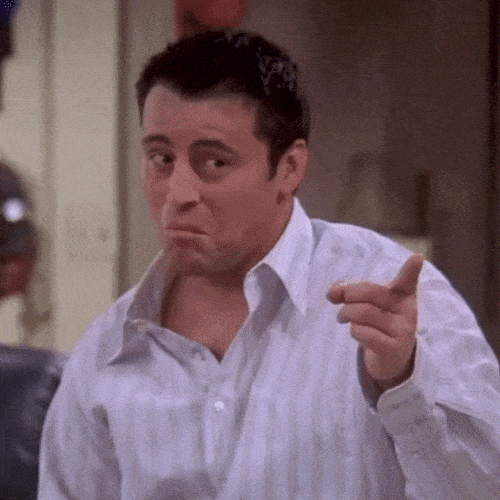 Man in a white shirt pointing with a confident expression
