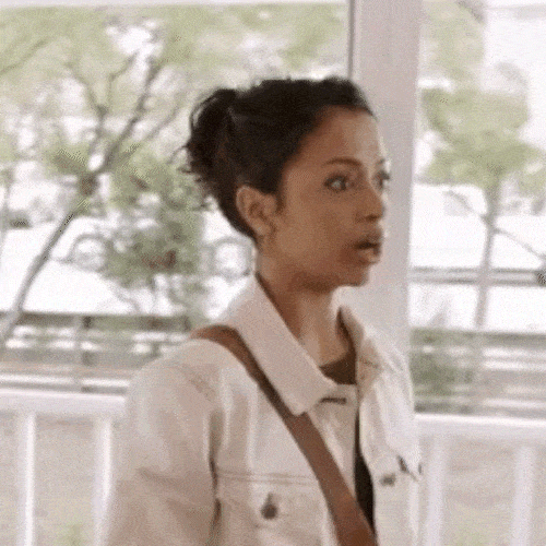 Woman in a white jacket looking around amazed