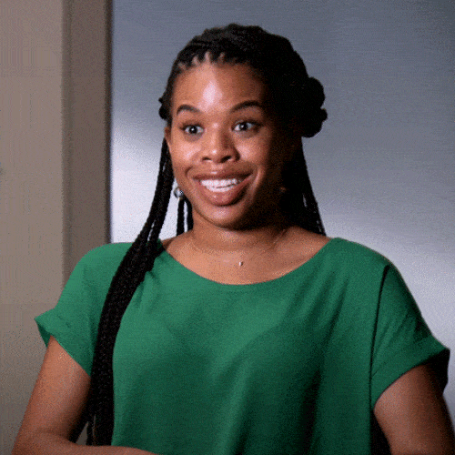 Woman in a green top smiling brightly