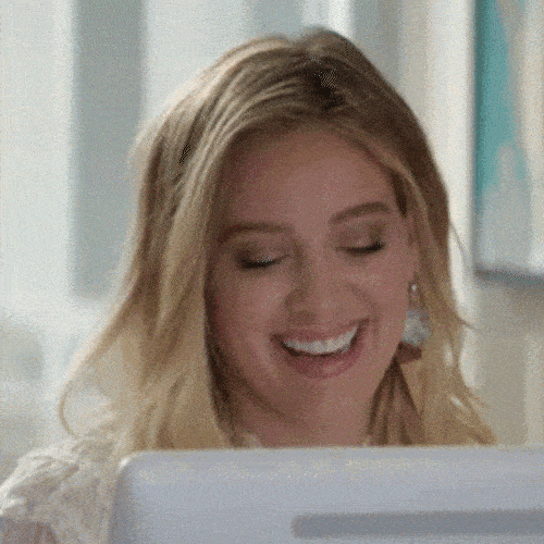 Woman smiling shyly at her computer screen