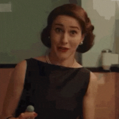Woman in a black dress looking impressed 