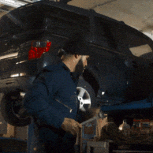 Car repairman working on a car in a garage