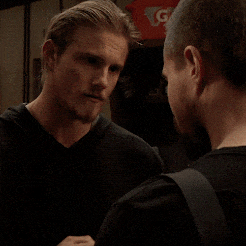 Two men standing close together, shaking hands
