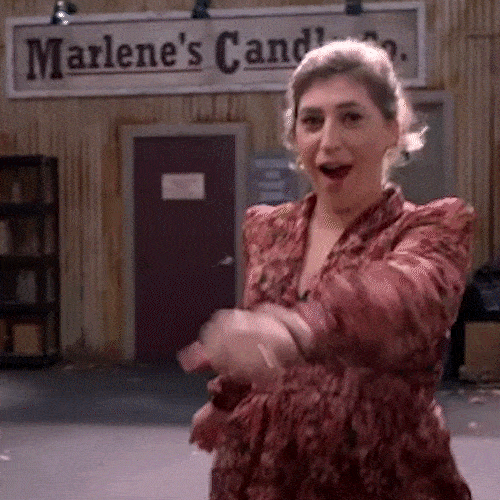 A woman dances excitedly as a group of friends joins in behind her.