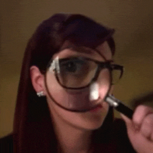 Person examining something closely with a magnifying glass, symbolizing attention to detail in editing