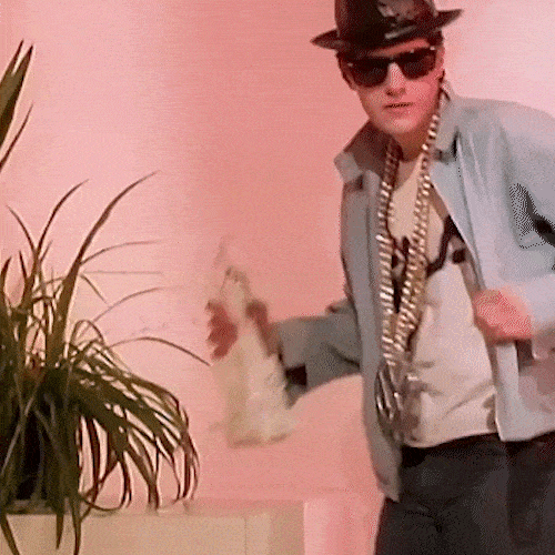 A man in a hat and sunglasses glances around and quickly ducks out of sight.