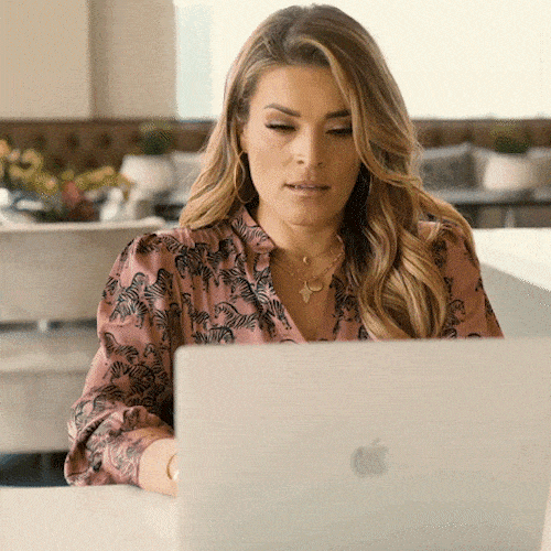 A woman working on her laptop looking visibly tired