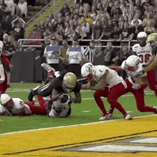 Football players collide in a pile at the goal line.