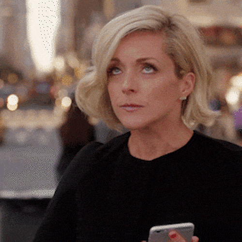 A blonde woman points two fingers at her eyes, as if to say she's keeping watch.