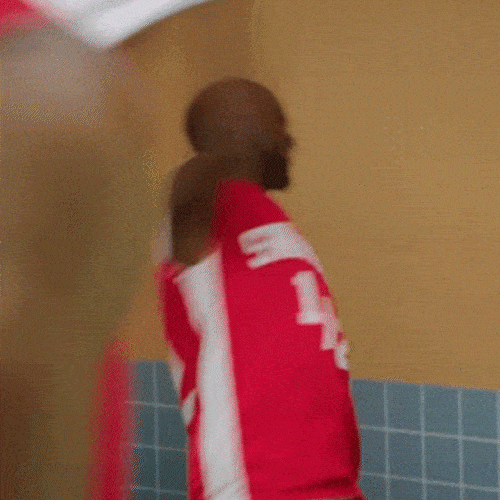 Person in a red sports jersey tossing a towel away