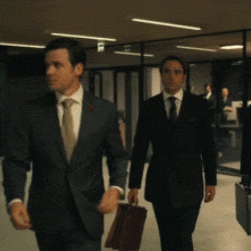 Two men in suits walking through an office
