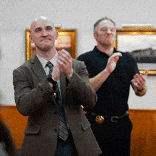Two men in a room applauding