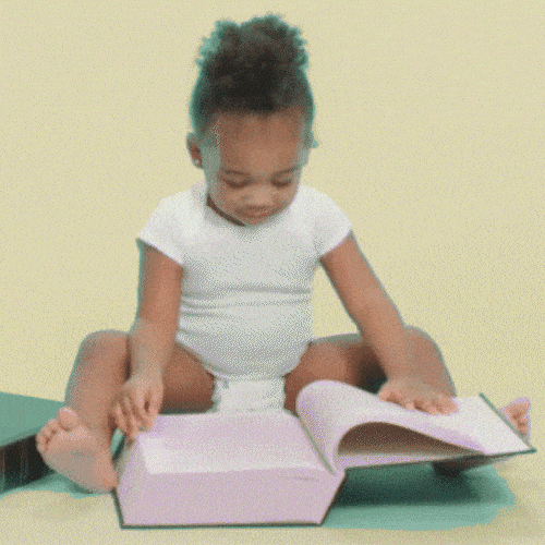 Little girl flipping through the pages of a big book 