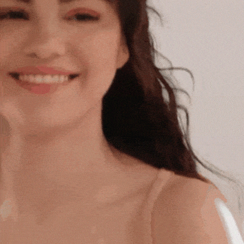 Woman with dark hair smiling warmly up close