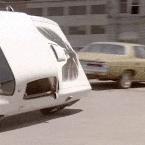 A car flips over and crashes onto a parked car on a city street.