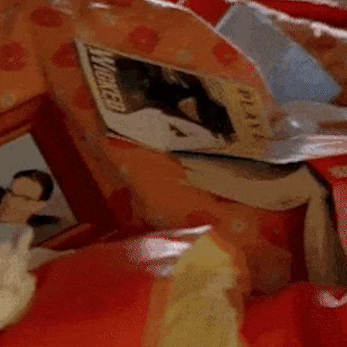 A woman curled up under a blanket in bed looks unwell.