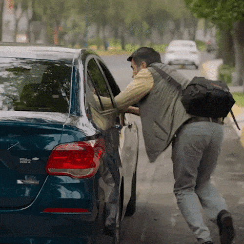 A car driving past a man on a street