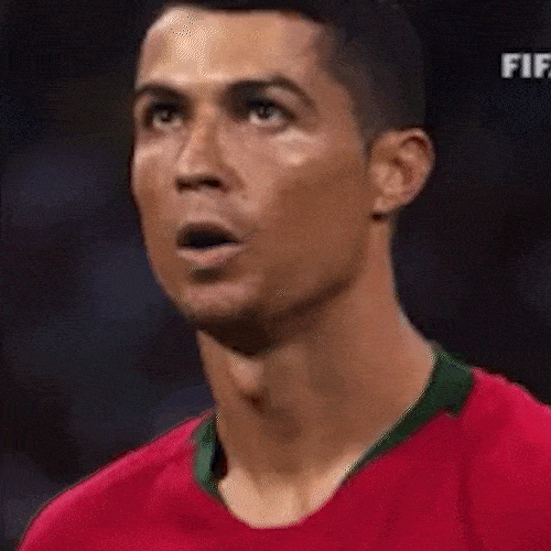 A football player in a red jersey takes a deep breath in and lets it out slowly.